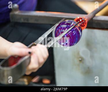 Le verre fondu est transformé en ornement au point de fusion soufflage du verre / art du verre au musée du verre de Corning Banque D'Images