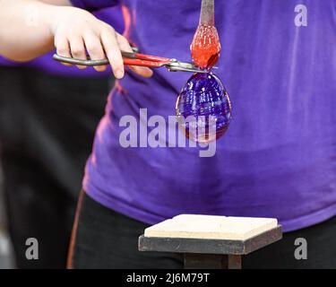 Le verre fondu est transformé en ornement au point de fusion soufflage du verre / art du verre au musée du verre de Corning Banque D'Images