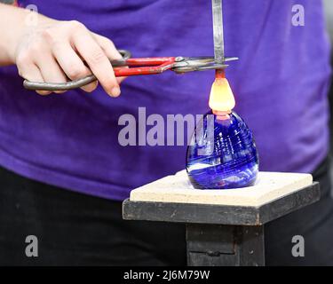 Le verre fondu est transformé en ornement au point de fusion soufflage du verre / art du verre au musée du verre de Corning Banque D'Images