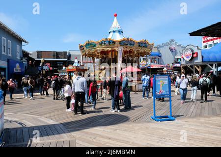 Carrousel, boutiques et visiteurs à l'embarcadère 39 de San Francisco, Californie, États-Unis par une journée ensoleillée ; tourisme et touristes dans la région de la baie. Banque D'Images