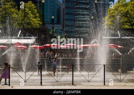 Enfants jouant dans la fontaine avec des buses d'eau venant de dessous, heureux et curieux. Drôle de temps d'enfance. Été. Jour ensoleillé Banque D'Images