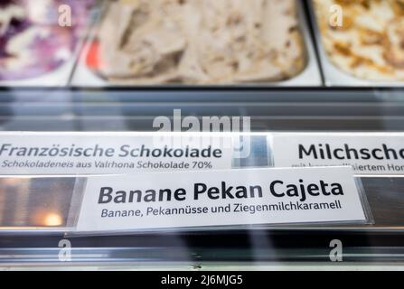 PRODUCTION - 28 avril 2022, Berlin: Dans un magasin de crème glacée à Prenzlauer Berg, la variété de crème glacée Banana Pekan Cajeta est offerte. Beaucoup de gens sont familiers avec le fait que les villes et les villages deviennent d'abord plus beaux, puis plus chers. Mais comment pouvez-vous dire aujourd'hui qu'un quartier est de plus en plus haut de gamme? Venez d'abord les étudiants et les artistes, puis les cafés et les restaurants. Le grand salon de crème glacée aux saveurs telles que pomme-basilic ou banane-pecan-chèvre lait-caramel. (À dpa: 'Première hanche, puis cher - Comment reconnaître le changement dans la ville') photo: Christophe bateau/dpa Banque D'Images