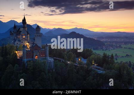 Belle vue en soirée du château de Neuschwanstein, avec des couleurs d'automne au coucher du soleil, Alpes bavaroises, Bavière, Allemagne Banque D'Images