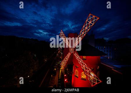 Vue générale extérieure du cabaret du Moulin Rouge à Paris, le 9 août 2021. Conçue pour ramener les clients dans le temps à la fin du 19th siècle, la salle isolée à l'intérieur du moulin à vent a été transformée en un boudoir inspiré de la Belle époque, rappelant l'époque du cabaret. Il n'a jamais été ouvert au public avant, donc vous devrez être rapide si vous voulez réserver votre séjour. Les trois invités chanceux bénéficieront d'un accès sur les coulisses au théâtre, d'un repas français traditionnel de trois plats, des meilleures places pour le spectacle Feerie du Moulin Rouge et d'un séjour d'une nuit à l'intérieur du célèbre moulin à vent. Le Banque D'Images