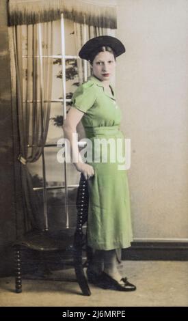 Photographie de portrait d'une jeune femme juive en robe de thé croisée vert long et chapeau, c1935 Banque D'Images