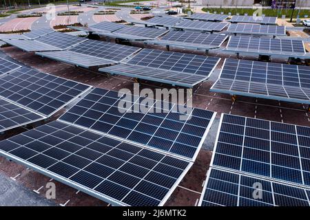 Vue aérienne au-dessus de panneaux solaires innovants situés sur les toits d'un parking de voiture faisant bon usage de petits espaces dans une ville Banque D'Images