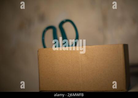 Boîte en carton avec ciseaux. Outil de coupe du papier. Carton dans la chambre. Banque D'Images