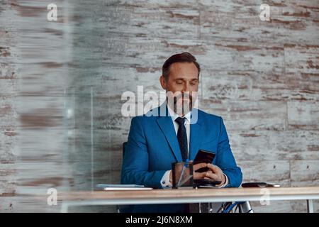 Homme barbu concentré tapant sur son téléphone portable Banque D'Images