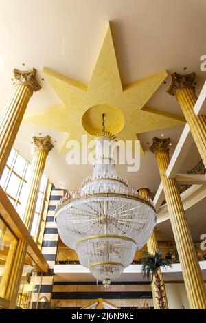 Un immense lustre de style classique au plafond d'un hôtel moderne. Banque D'Images