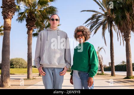 couple d'amis souriant heureux regardant la caméra à côté des palmiers, concept d'amitié et de relation de couple Banque D'Images