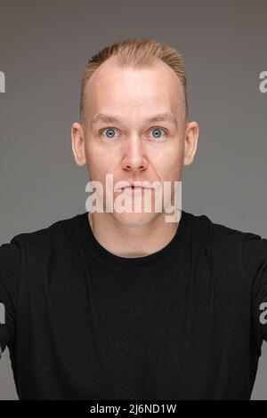 Scène photo de l'homme choqué dans des vêtements noirs Banque D'Images