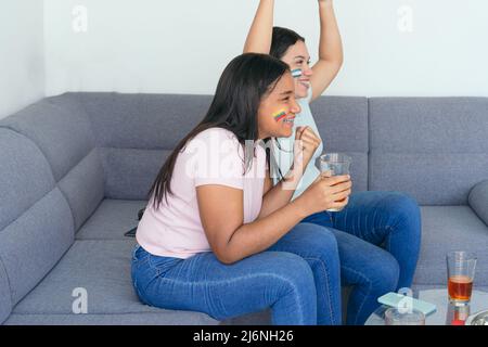 Des amies latino-américaines regardant un match de football à la maison Banque D'Images