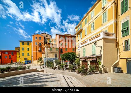 Maisons colorées traditionnelles sous ciel bleu avec des nuages blancs dans la vieille ville de Menton - célèbre et populaire station balnéaire sur la Côte d'Azur. Banque D'Images