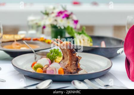 Carré d'agneau rôti avec purée de pommes de terre et d'oignons sur la table dans le restaurant de luxe Banque D'Images