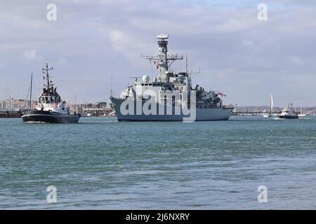 La frégate de type 23 de la Marine royale HMS WESTMINSTER est escortée vers l'embouchure du port alors qu'elle navigue depuis la base navale Banque D'Images