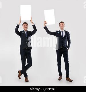 Homme d'affaires tenant blanc blanc panneau publicitaire au studio, montage d'image Banque D'Images
