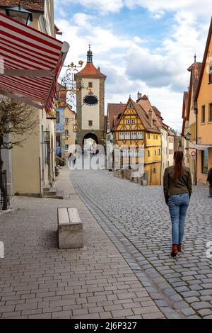 Belle architecture romantique de Rothenburg ob der Tauber avec maisons à colombages Fachwerkhaus syle en Bavière Allemagne avec une touriste marchant. Banque D'Images