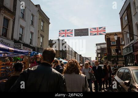 Personnes dans la rue, visite du marché de la route de Portobello à Notting Hill, Londres. Les touristes marchant et faisant du shopping depuis les stands du marché. Banque D'Images