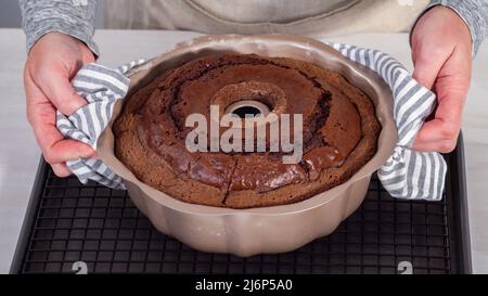 Étape par étape. Refroidir le gâteau au chocolat fraîchement cuit sur une grille de refroidissement. Banque D'Images