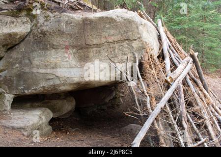 Penchez-vous à Wood Shelter sur Rock Cave Banque D'Images