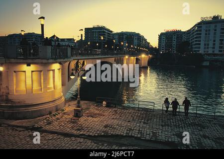 02 janv. 2022 - Séville, Espagne : photo de nuit stylisée du pont Puente de San Telmo dans le centre-ville de Séville, face au fleuve Guadalquivir Banque D'Images