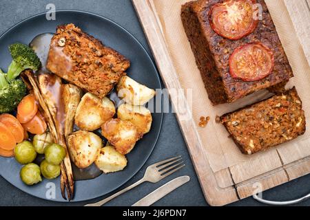 Rôti de noix de vegan / pain de noix sur une planche de bois avec un dîner de rôti de noix. ROYAUME-UNI Banque D'Images