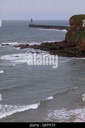 Tynemouth, North Shields, Angleterre. Mai 2022. Nuageux et frais au bord de mer du nord-est pour les quelques personnes sur la plage, température de l'après-midi de 11 degrés avant la pluie fixé à tard après midi. Photo : petites vagues arrivant sur la rive avec le phare de Tynemouh Pier en arrière-plan. Credit: Archwhite/alamy Live news. Banque D'Images