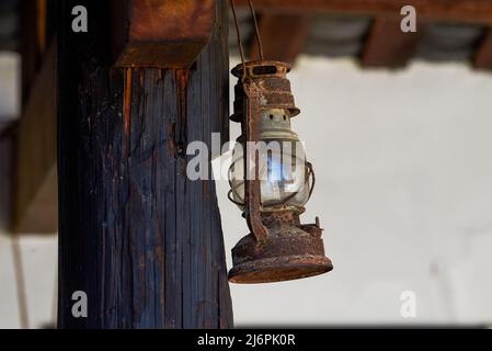 Gros plan d'une lampe rétro à kérosène accrochée à un piquet en bois Banque D'Images