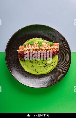 Gros plan sur un délicieux plat de tatatataki au saumon japonais recouvert de sésame et servi avec des bandes croustillantes. Isolé sur un fond moderne. Sélectif Banque D'Images