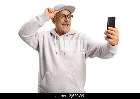 Souriant, homme mûr et frais prenant un selfie avec un smartphone isolé sur fond blanc Banque D'Images