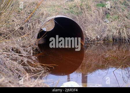 Tuyau d'égout rond noyé avec de l'eau sale. Problème d'écologie de l'eau polluée Banque D'Images