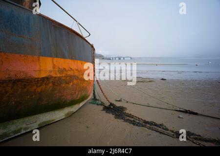 Vessell s'est enaché sur le sable au port de Barmouth avec le pont ferroviaire en arrière-plan Banque D'Images