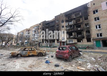 Guerre de la Russie contre l'Ukraine. Voiture brûlée sur le fond d'une maison brûlée Banque D'Images