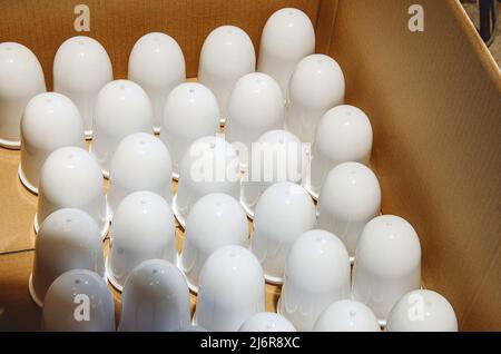 Vue de dessus des abat-jour blancs aux lampes de la boîte. Fabrication de lampes. Banque D'Images