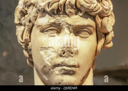 Gros plan de la tête de l'ancienne statue en marbre de la jeune grecque attrayante avec des parties du visage ébréchées et détruites Banque D'Images