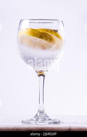 verre tonique de gin avec tranches de citron sur fond blanc Banque D'Images