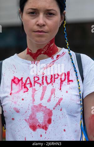 Kiev, Ukraine, 3 mai 2022, T-shirt avec des traces de peinture rouge symbolisant le sang des victimes innocentes de la guerre. Les jeunes militantes se préparent au rassemblement en appliquant de la peinture rouge sur elles-mêmes, symbolisant le sang. Des femmes, des mères, des enfants de soldats ukrainiens et des membres du bataillon Azov à Marioupol se sont réunis sur la place de l'indépendance pour assister à un rassemblement pour appeler les leaders mondiaux à l'action pour aider à organiser un couloir humanitaire pour l'évacuation des civils et des militaires ukrainiens de la ville assiégée de Marioupol vers les pays neutres, Kiev, Ukraine, 3 mai 2022 Banque D'Images