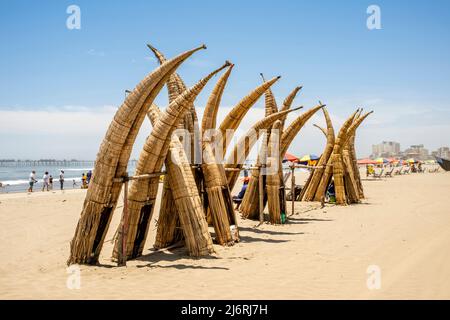 Caballitos de Totoro (bateaux à lames traditionnelles) empilé sur la plage de Pimentel, Chiclayo, province de Chiclayo, Pérou. Banque D'Images