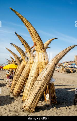 Caballitos de Totoro (bateaux à lames traditionnelles) empilé sur la plage de Pimentel, Chiclayo, province de Chiclayo, Pérou. Banque D'Images