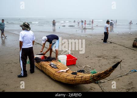 Les gens de la région vendent du poisson frais de leurs Caballitos de Totora (bateaux à lames traditionnels), Plage de Pimentel, Chiclayo, province de Chiclayo, Pérou. Banque D'Images