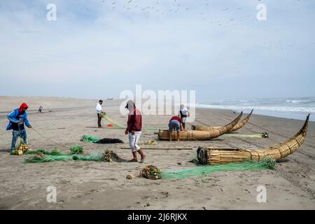 Les pêcheurs locaux se préparent à pêcher dans leurs Caballitos de Totora (bateaux à lames traditionnels), Santa Rosa Beach, Chiclayo, province de Chiclayo, Pérou. Banque D'Images