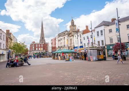 Les acheteurs s'asseoir et marcher sur la place du marché, Hereford Herefordshire, Angleterre. Banque D'Images