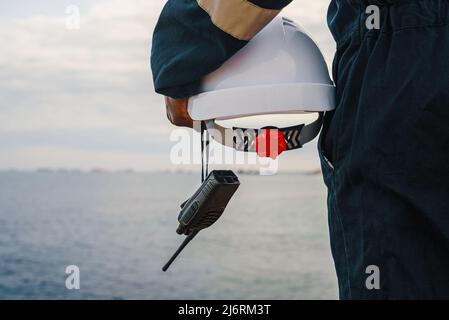 Croiser un employé de sexe masculin avec un casque et une radio en mer Banque D'Images