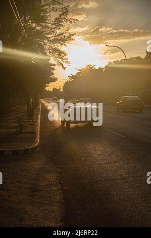 Un Chevrolet rouge vintage traverse la rue au crépuscule à Varadero, Cuba. Banque D'Images