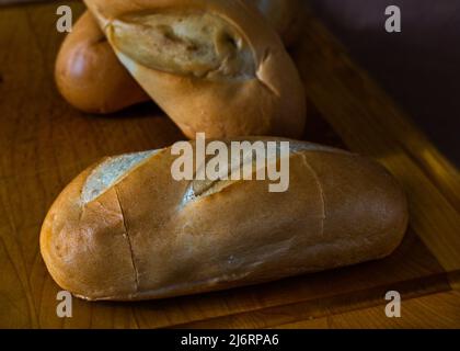 Petits pains au lait frais faits maison, pain savoureux, petits pains, tout sur une planche à découper et tout dans une atmosphère de petit déjeuner. Banque D'Images