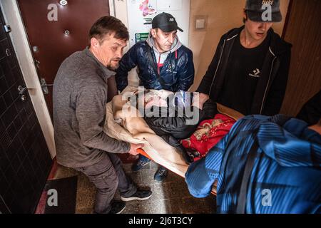 Des volontaires du centre informel d'aide humanitaire 'vvolunter68' évacuent Kiseleva Larisa Anatolyevna, 55 ans, qui a la sclérose en plaques, de son appartement dans le quartier fortement bombardé de Saltivka à la gare de Kharkiv, où elle prendra le train pour Lviv puis se rendra en Pologne. La Russie a envahi l'Ukraine le 24 février 2022, déclenchant la plus grande attaque militaire en Europe depuis la Seconde Guerre mondiale Banque D'Images