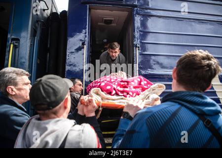 Des volontaires du centre informel d'aide humanitaire 'vvolunter68' évacuent Kiseleva Larisa Anatolyevna, 55 ans, qui a la sclérose en plaques, de son appartement dans le quartier fortement bombardé de Saltivka à la gare de Kharkiv, où elle prendra le train pour Lviv puis se rendra en Pologne. La Russie a envahi l'Ukraine le 24 février 2022, déclenchant la plus grande attaque militaire en Europe depuis la Seconde Guerre mondiale Banque D'Images