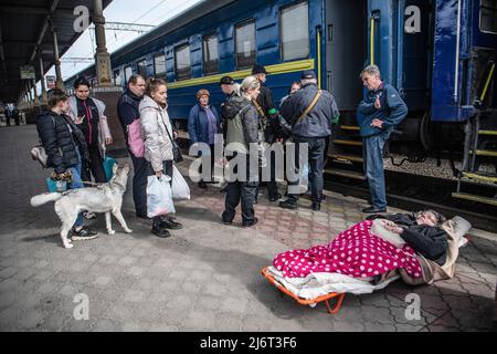 Des volontaires du centre informel d'aide humanitaire 'vvolunter68' évacuent Kiseleva Larisa Anatolyevna, 55 ans, qui a la sclérose en plaques, de son appartement dans le quartier fortement bombardé de Saltivka à la gare de Kharkiv, où elle prendra le train pour Lviv puis se rendra en Pologne. La Russie a envahi l'Ukraine le 24 février 2022, déclenchant la plus grande attaque militaire en Europe depuis la Seconde Guerre mondiale Banque D'Images