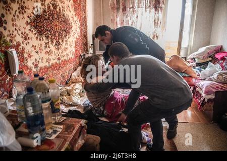 Des volontaires du centre informel d'aide humanitaire 'vvolunter68' évacuent Kiseleva Larisa Anatolyevna, 55 ans, qui a la sclérose en plaques, de son appartement dans le quartier fortement bombardé de Saltivka à la gare de Kharkiv, où elle prendra le train pour Lviv puis se rendra en Pologne. (Photo par Laurel Chor / SOPA Images / Sipa USA) Banque D'Images