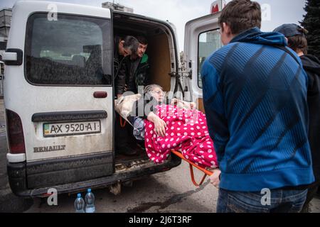 Des volontaires du centre informel d'aide humanitaire 'vvolunter68' évacuent Kiseleva Larisa Anatolyevna, 55 ans, qui a la sclérose en plaques, de son appartement dans le quartier fortement bombardé de Saltivka à la gare de Kharkiv, où elle prendra le train pour Lviv puis se rendra en Pologne. (Photo par Laurel Chor / SOPA Images / Sipa USA) Banque D'Images